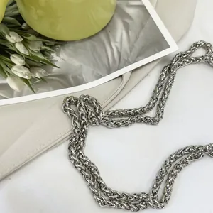 Detail shot of a silver woven metal chain strap with polished luxury finish