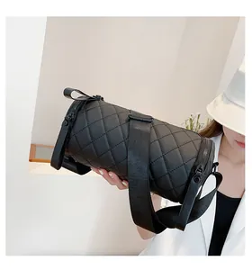 Close-up of a black quilted cylinder bag showing waterproof nylon texture and wide strap