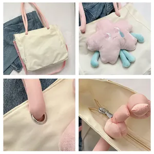 Dettaglio della borsa tote in tela crema con manici rosa e ciondolo a forma di stella