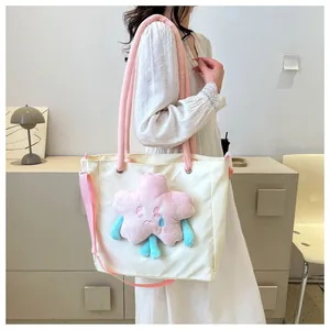 Dettaglio della borsa tote in tela bianca con stella di peluche rosa e tracolla