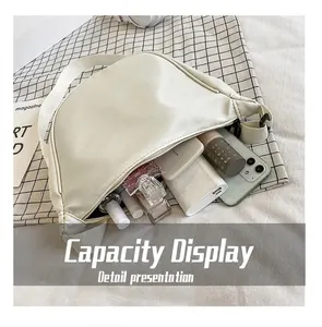 Vista detallada del bolso de nailon crema en forma de medialuna con gran capacidad interior