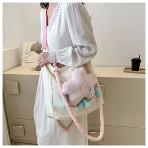 Dettaglio borsa tote in tela crema con stella di peluche rosa e manici morbidi sul modello