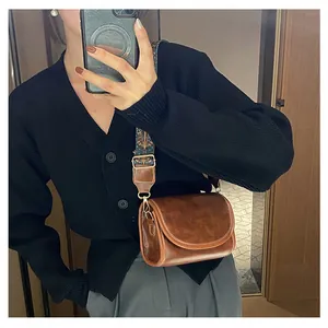 Sac bandoulière rétro marron en cuir vintage avec une large sangle en jacquard coloré
