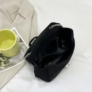 Interior view of black rhinestone square bag with zipper pocket and silver chain strap