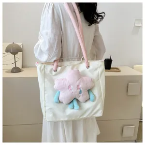 Dettaglio della borsa tote crema con stella di peluche rosa e spalline rosa