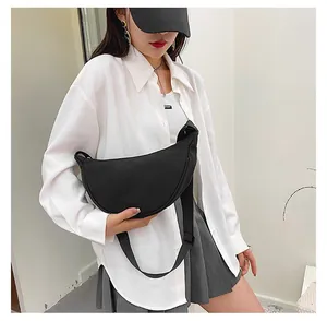 Close-up of black crescent dumpling bag with adjustable wide strap on a model