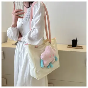 Dettaglio della borsa tote in tela crema con manici in corda rosa e peluche a stella