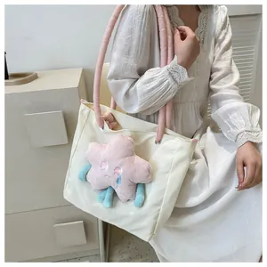 Dettaglio di una borsa tote in tela bianca con stella di peluche rosa e manici