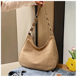 Close-up van kaki suède hobo tas met elegante leren en goudkleurige ketting schouderband