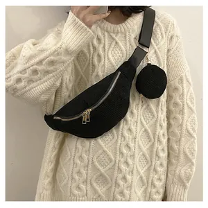 Detail of black corduroy crescent crossbody bag with mini pouch and gold hardware