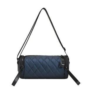 Navy blue quilted barrel crossbody bag with nylon texture and wide shoulder strap