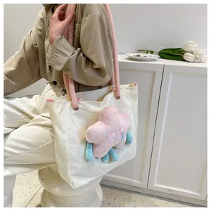 Dettaglio della borsa tote bianca con manici rosa e ciondolo a stella in peluche 3D