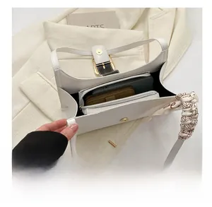 Detail view showing large interior capacity of the white quilted handbag with silk scarf