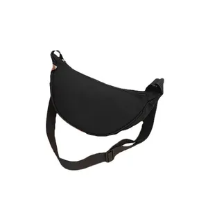 Minimalist black nylon crescent crossbody bag with adjustable strap on white background