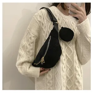 Detail of black corduroy crossbody bag with round coin purse and metal zipper closure