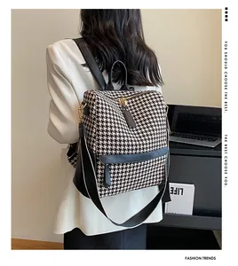 Détail du sac à dos rétro à motif pied-de-poule avec bordure en cuir sur mannequin