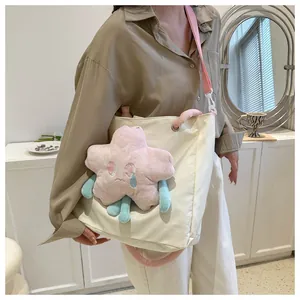 Borsa tote in tela con stella di peluche rosa e tracolla indossata da una modella