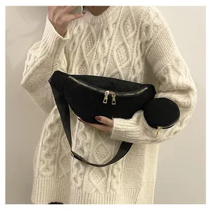 Detail of black corduroy crossbody bag with adjustable strap and small round pouch