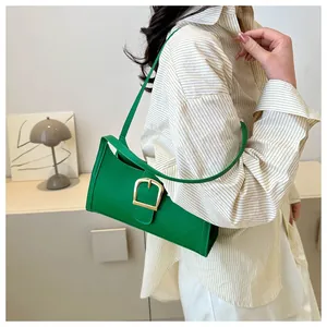 Close-up of vibrant green baguette bag with quilted texture and large golden buckle detail