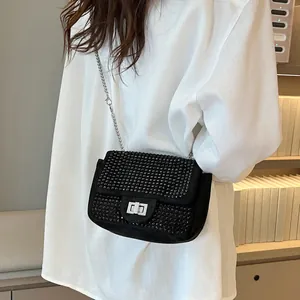 Chic black square bag with rhinestones and silver chain strap worn on white shirt