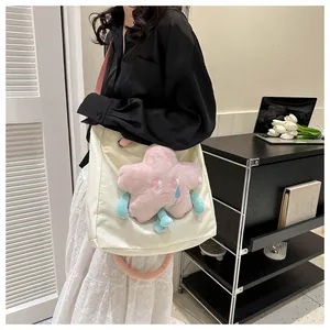 Dettaglio borsa tote in tela crema con peluche a stella rosa e tracolla rosa a contrasto