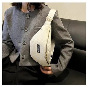Detailed close-up of white corduroy crossbody bag with Fashion Instinct label and gold buckle