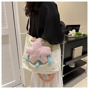 Dettaglio della borsa tote in tela crema con stella di peluche rosa e tracolla regolabile