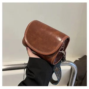 Détail du sac besace en cuir PU marron avec surpiqûres et bandoulière jacquard ethnique