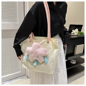 Dettaglio della borsa tote beige trendy con stella di peluche rosa e manici a corda