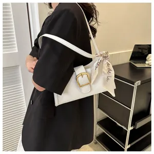 Close-up of white PU leather underarm bag with V-shaped quilting and silk scarf detail