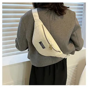 Detail of white corduroy crossbody bag with golden zippers and fashion slogan label