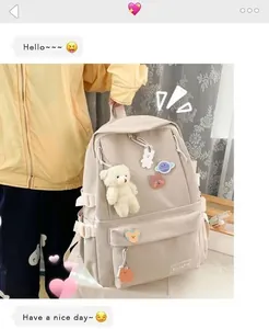 Dettaglio dello zaino in tela beige con ciondolo a forma di orso e spille decorative