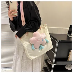 Dettaglio della borsa tote in nylon bianco crema con peluche a stella rosa in stile casual