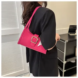 Detail of rose pink underarm bag with V-quilted faux leather and large gold buckle