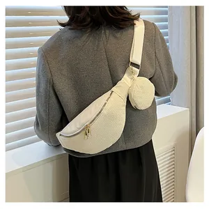 Detail of off-white corduroy crossbody bag with round pouch and gold metal zippers