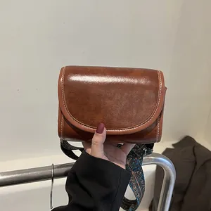 Sac bandoulière vintage en cuir marron avec large sangle ethnique et surpiqûres