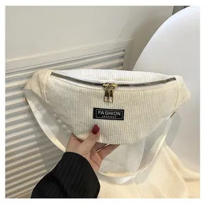 Detailed close-up of cream corduroy waist bag with gold zippers and fashion label