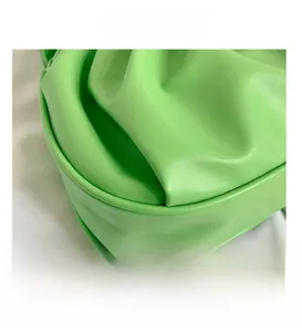 Macro detail of vibrant green leather ruched design and fine stitching of the cloud bag