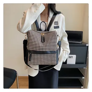 Détail de la texture en pied-de-poule et du zip doré sur ce sac à dos élégant