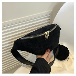 Detail of black corduroy crossbody bag with gold zippers and round coin purse attachment