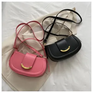Detailed top view of pink and black leather saddle bags with crescent metal buckles