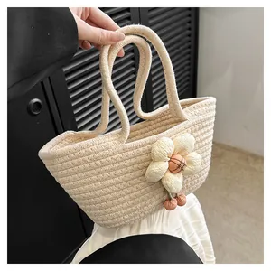 Detailansicht der beige gewebten Tragetasche mit großer 3D-Blume und Kirsch-Anhängern