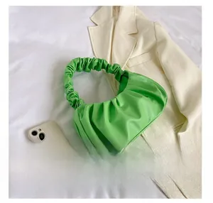 Detail presentation showing bright green pleated cloud bag texture and handle design