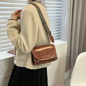 Sac bandoulière en cuir marron avec rabat vintage et large bandoulière tissée à motifs