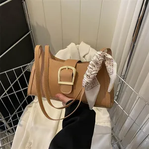 Light brown rectangular shoulder bag with V-stitch design and silk scarf accessory