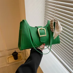 Green shoulder bag with V-quilted faux leather, gold buckle, and patterned silk scarf accent