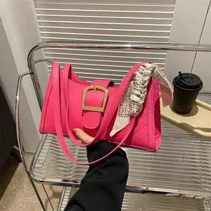 Hot pink quilted handbag with gold buckle and decorative silk scarf for modern women