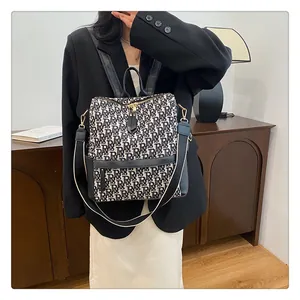 Détail du sac à dos avec motif monogramme, accents en cuir noir et bandoulière rayée