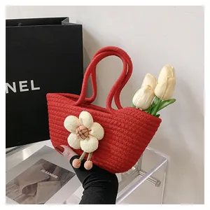 Detail der roten handgewebten Tasche aus Baumwollseil mit dekorativem 3D-Blumenanhänger