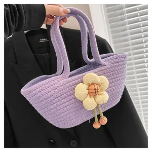 Nahaufnahme einer lila Stricktasche mit einer großen creme-farbenen 3D-Blumenverzierung